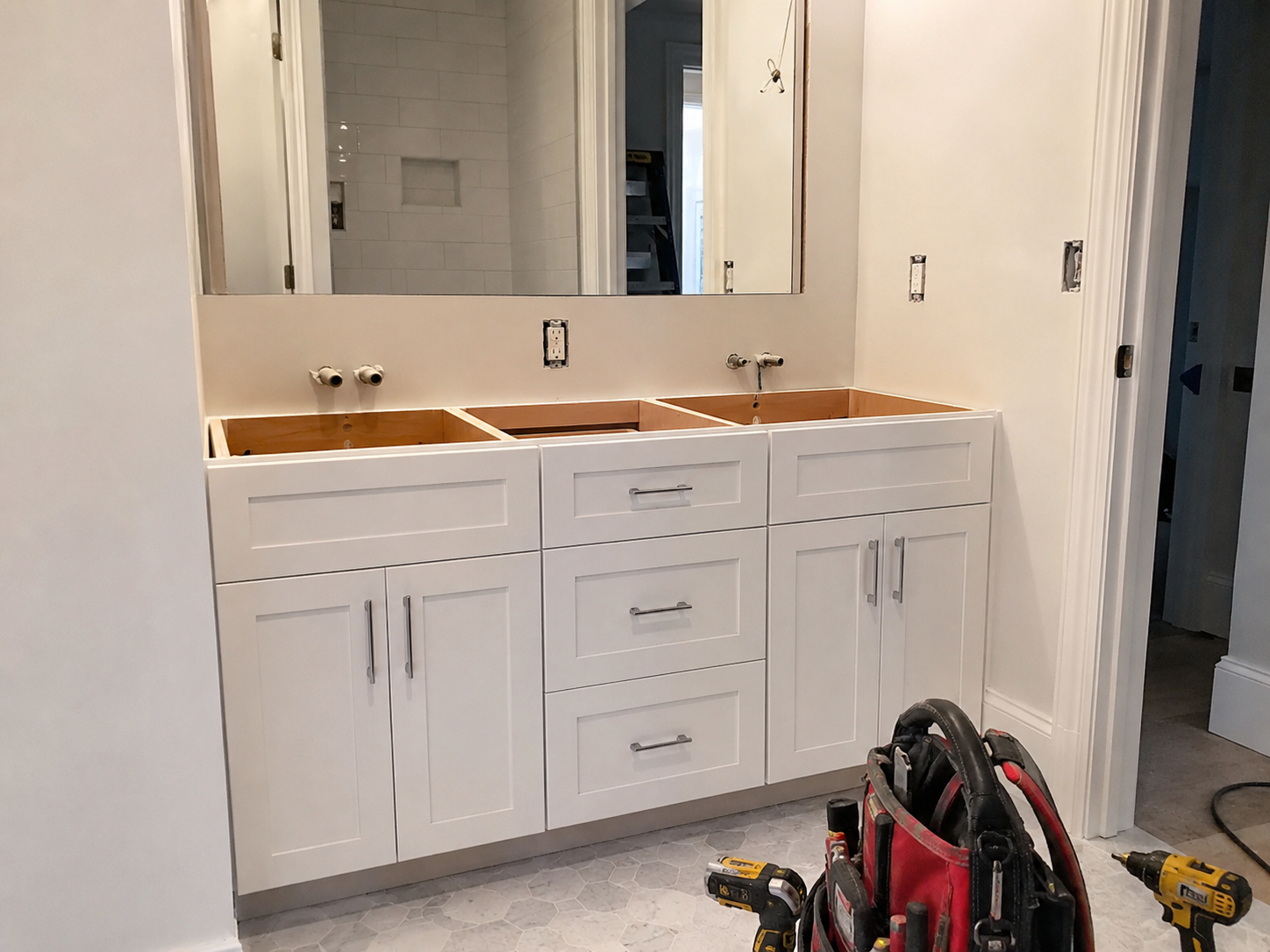 Bathroom vanity cabinet installation project with white shaker cabinets