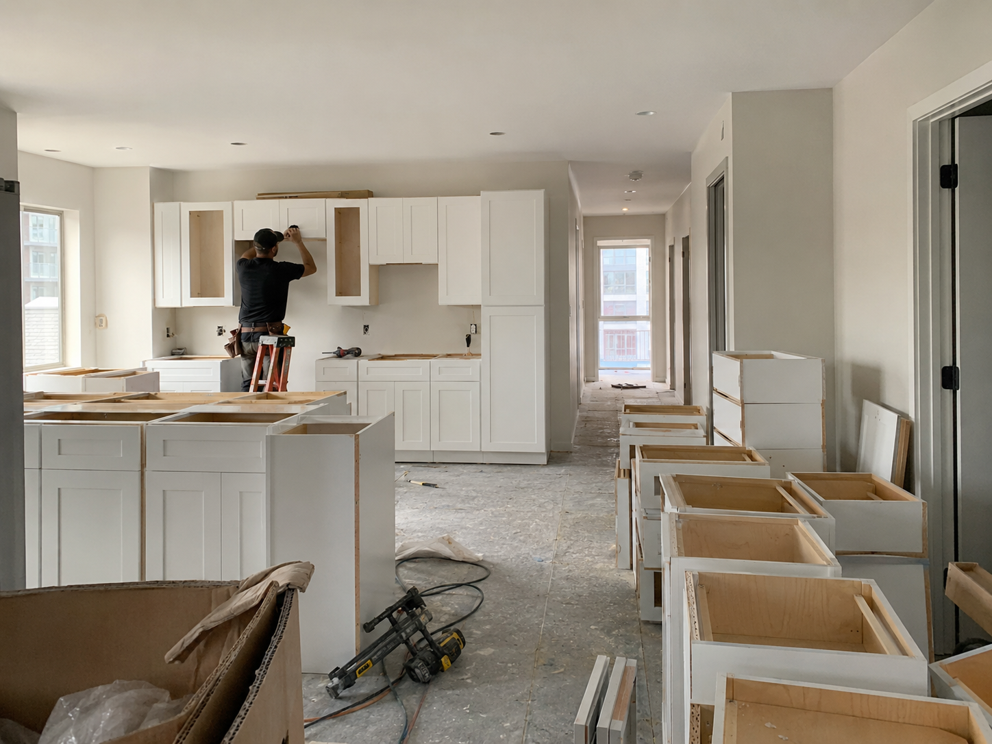 Multi-unit property cabinet supply project with white shaker cabinets staged for installation